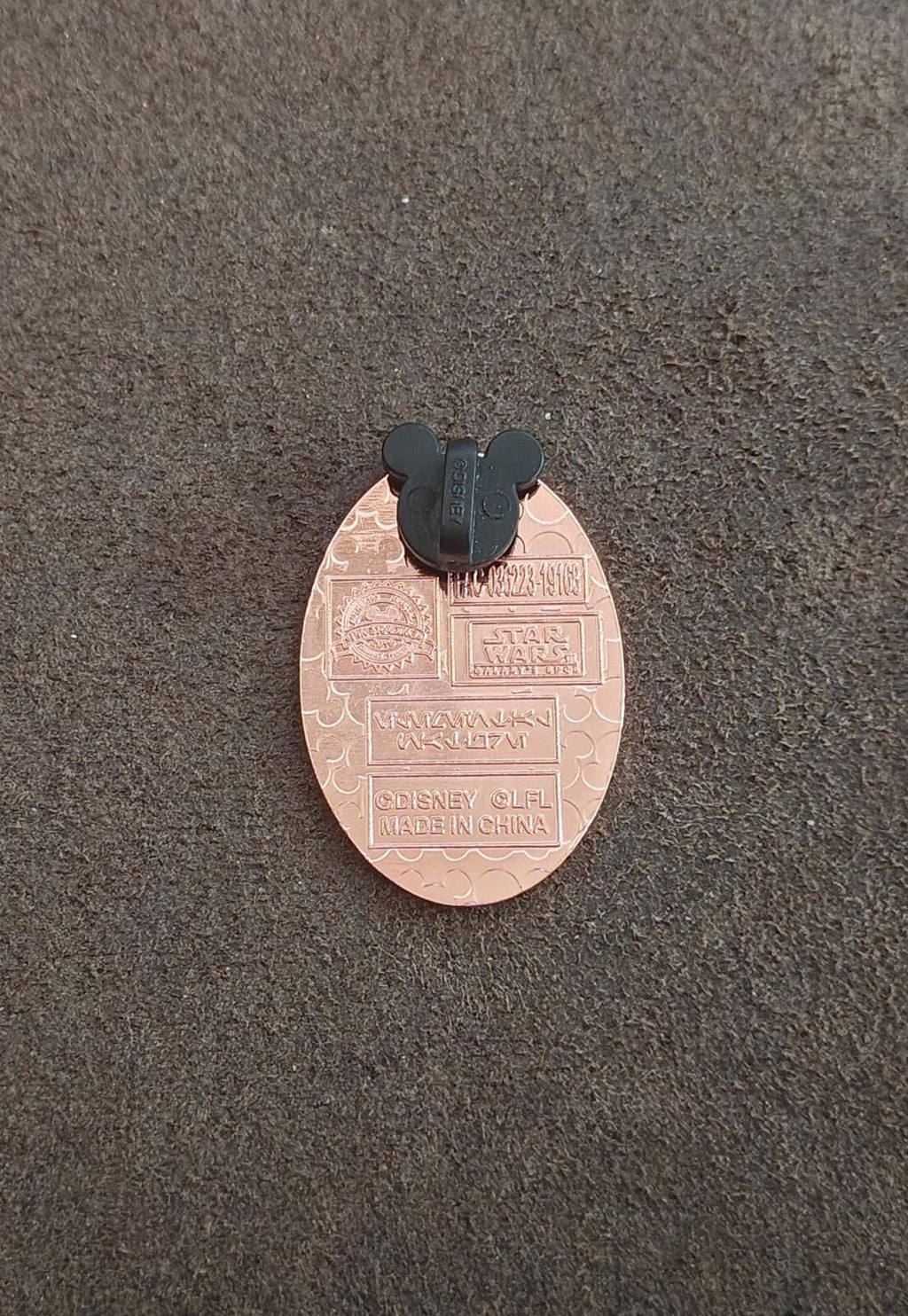 Apricot oval pin back with black Mickey-style clasp and engraved text plate
