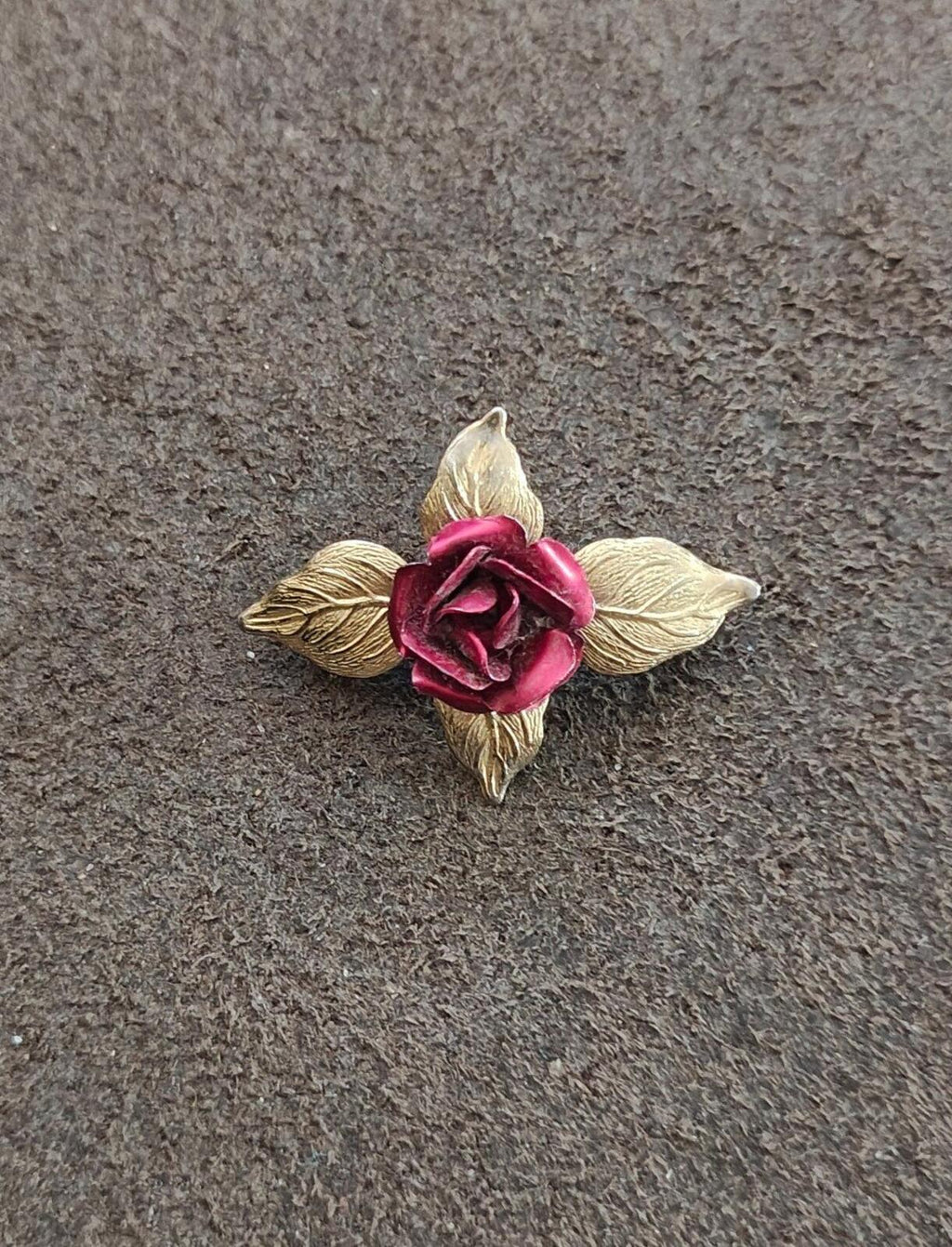 Gold-tone rose brooch with red enamel flower and sculpted leaf accents