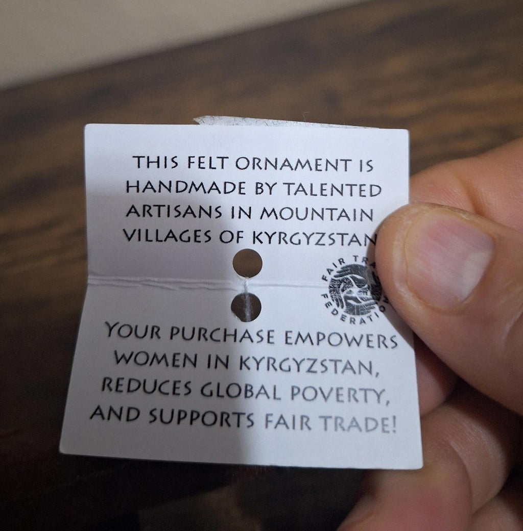 Printed message hang tag attached to felt ornament, white card with dark blue text
