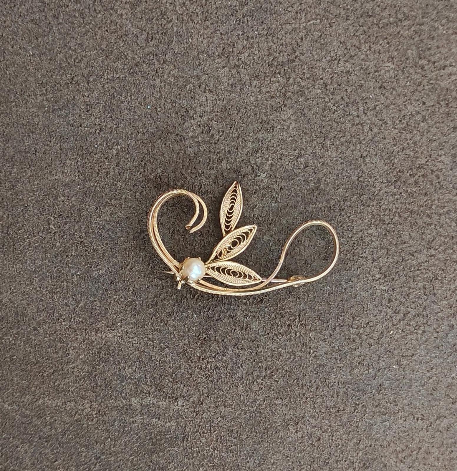 Gold tone leaf filigree brooch with faux pearl bead, curling vine and layered leaf shapes