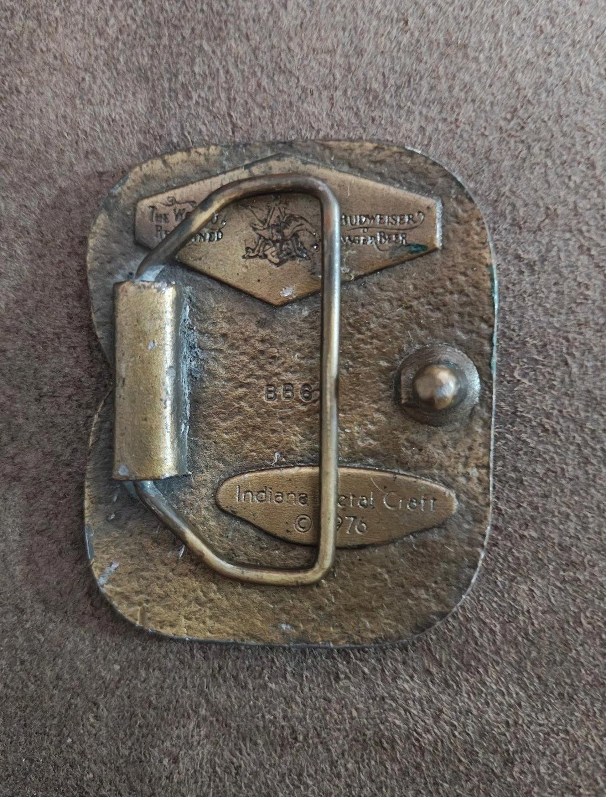 Vintage brass belt buckle back, engraved markings including "Indiana Metal Craft" and "© 1976".