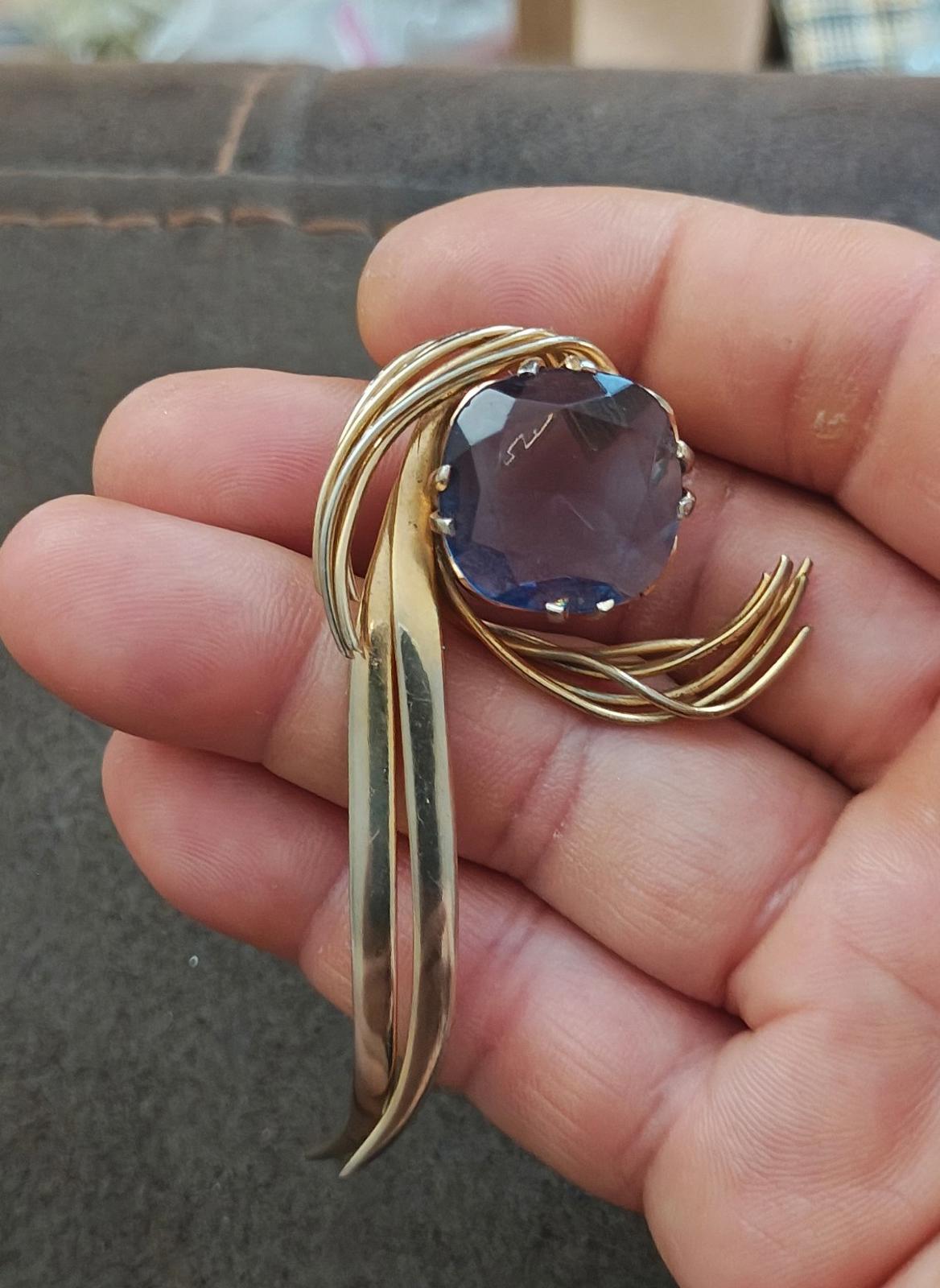 Gold-tone abstract brooch pin with blue gemstone and dangling gold-tone bar detail