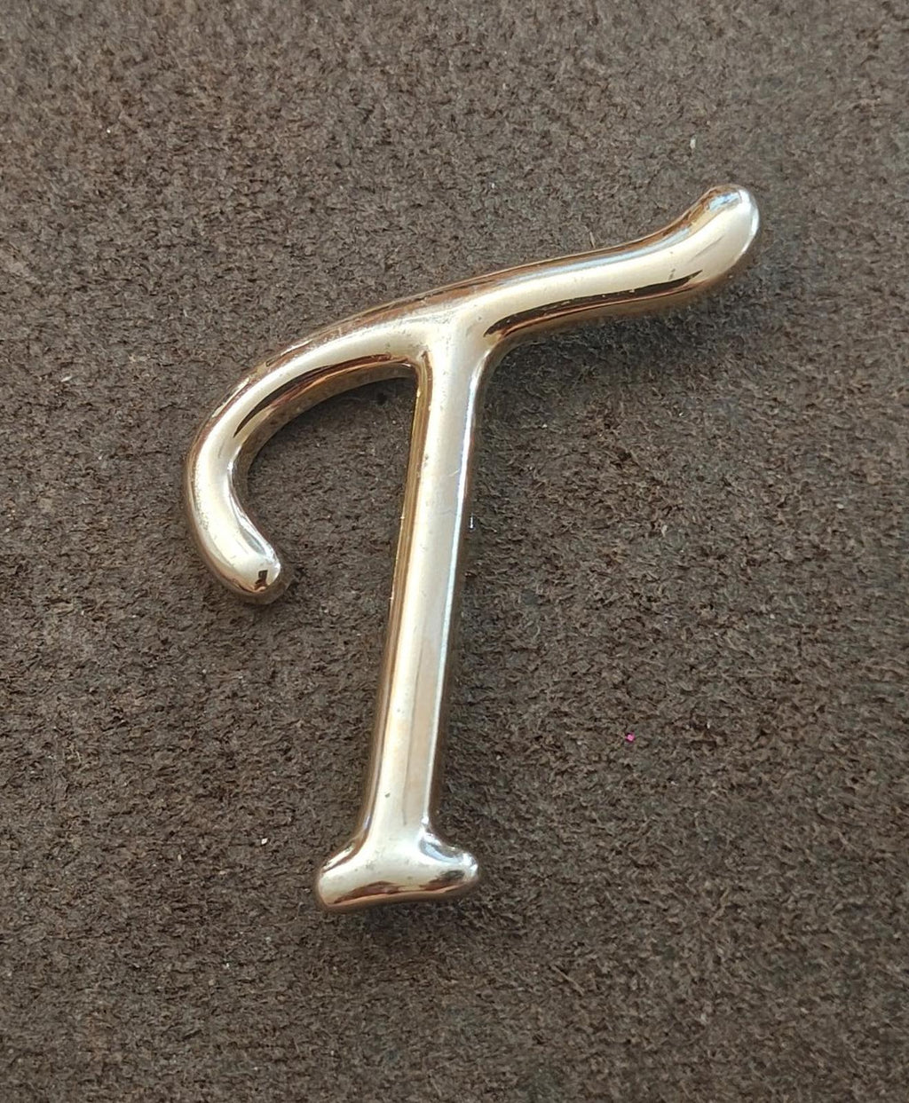 Silver-tone letter T pin/brooch, front view with curved top bar