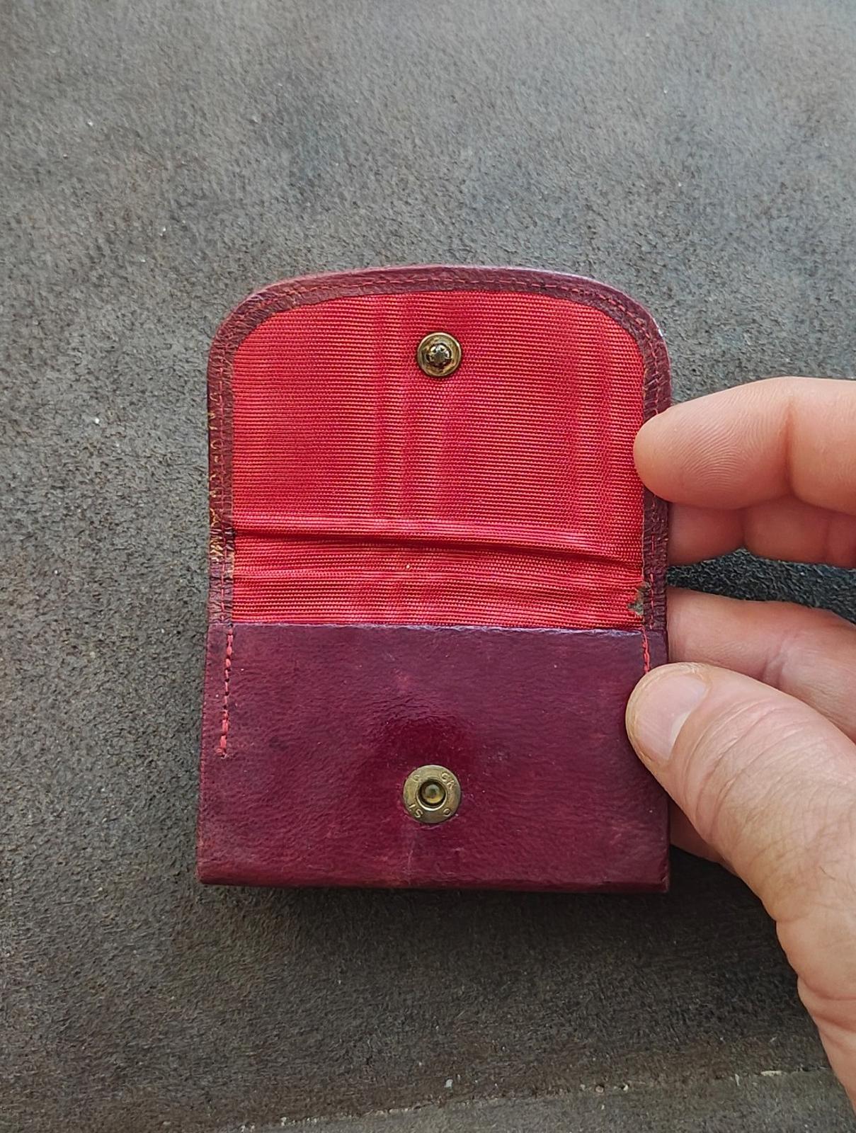 Small burgundy leather coin purse with red fabric lining and two brass snap buttons.