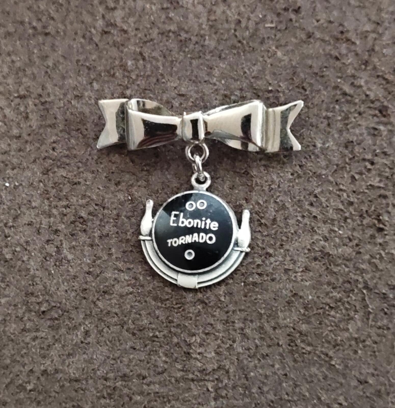 Silver tone bow bar pin with Ebonite Tornado round dangle