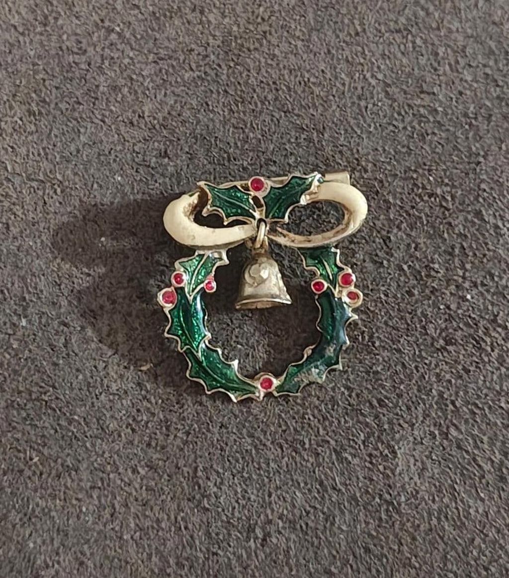 Gold-tone Christmas wreath brooch with green enamel, red berries, and hanging bell