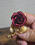 Gold-tone red rose enamel pin with gold leaves, rose centered close-up.