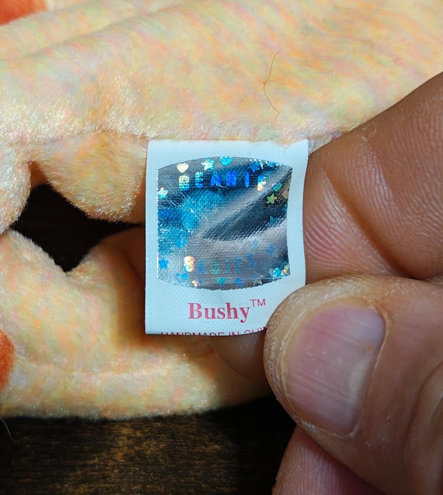Bushy product tag on rainbow-furred lion beanbag plush