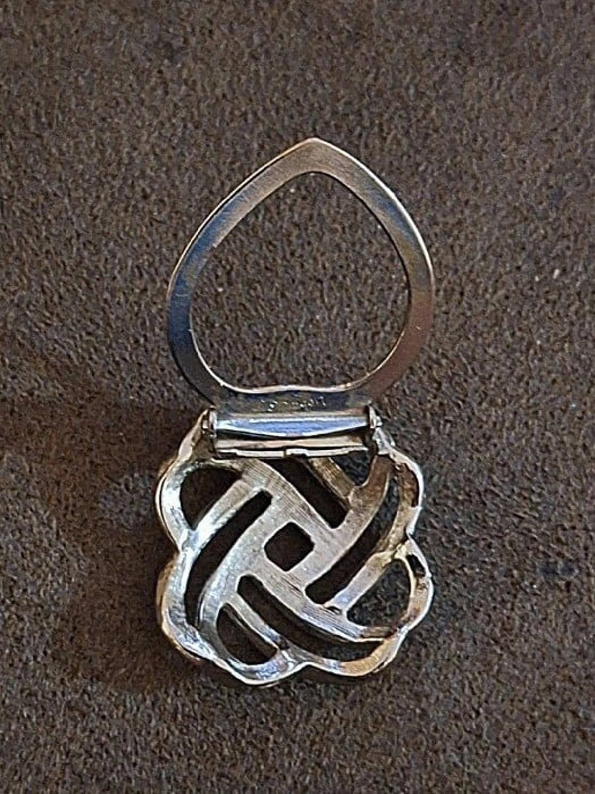 Silver love-knot scarf clip with teardrop loop and hinge clasp, side view