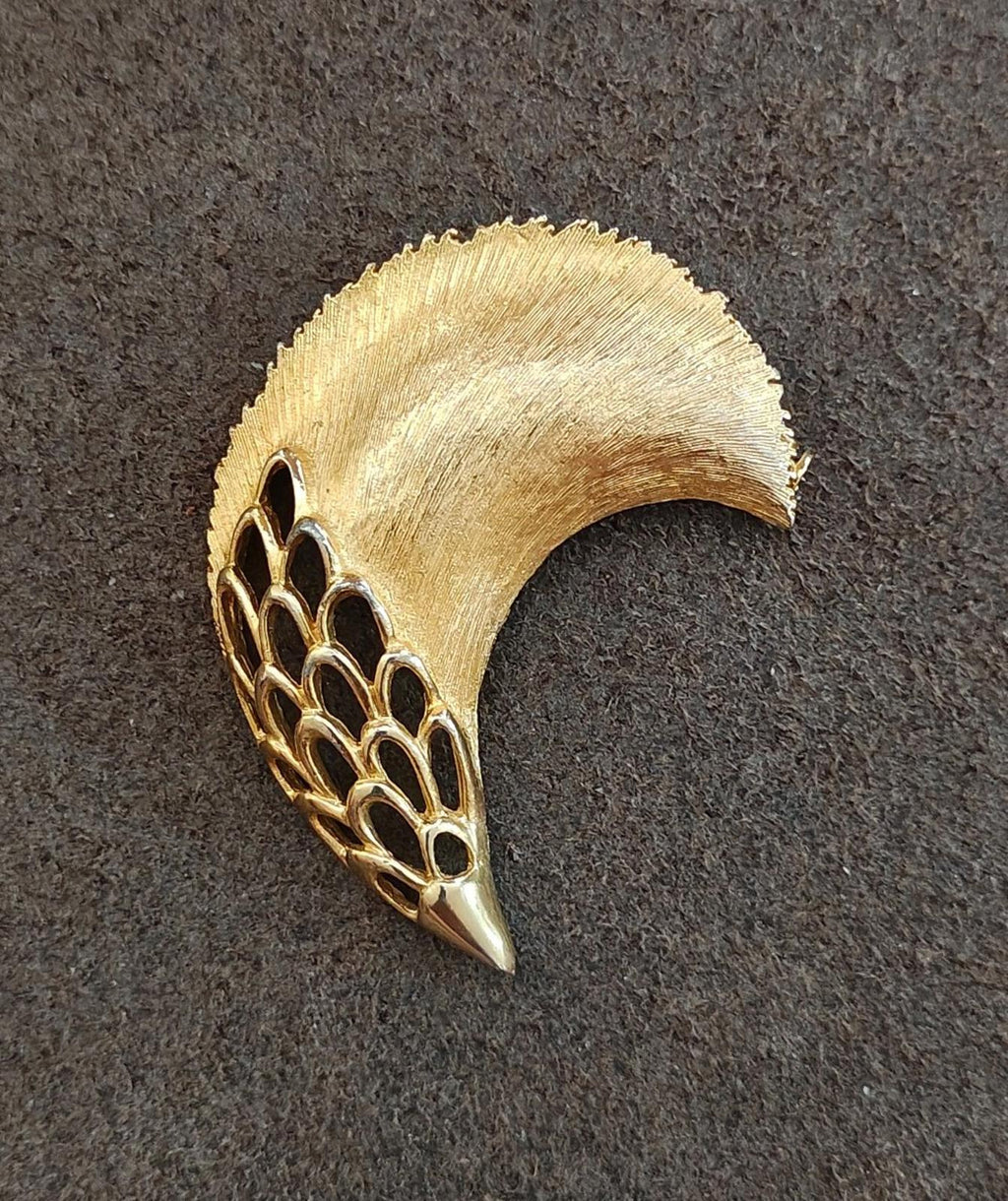 Gold tone feather plume brooch with textured plume and openwork mesh tail