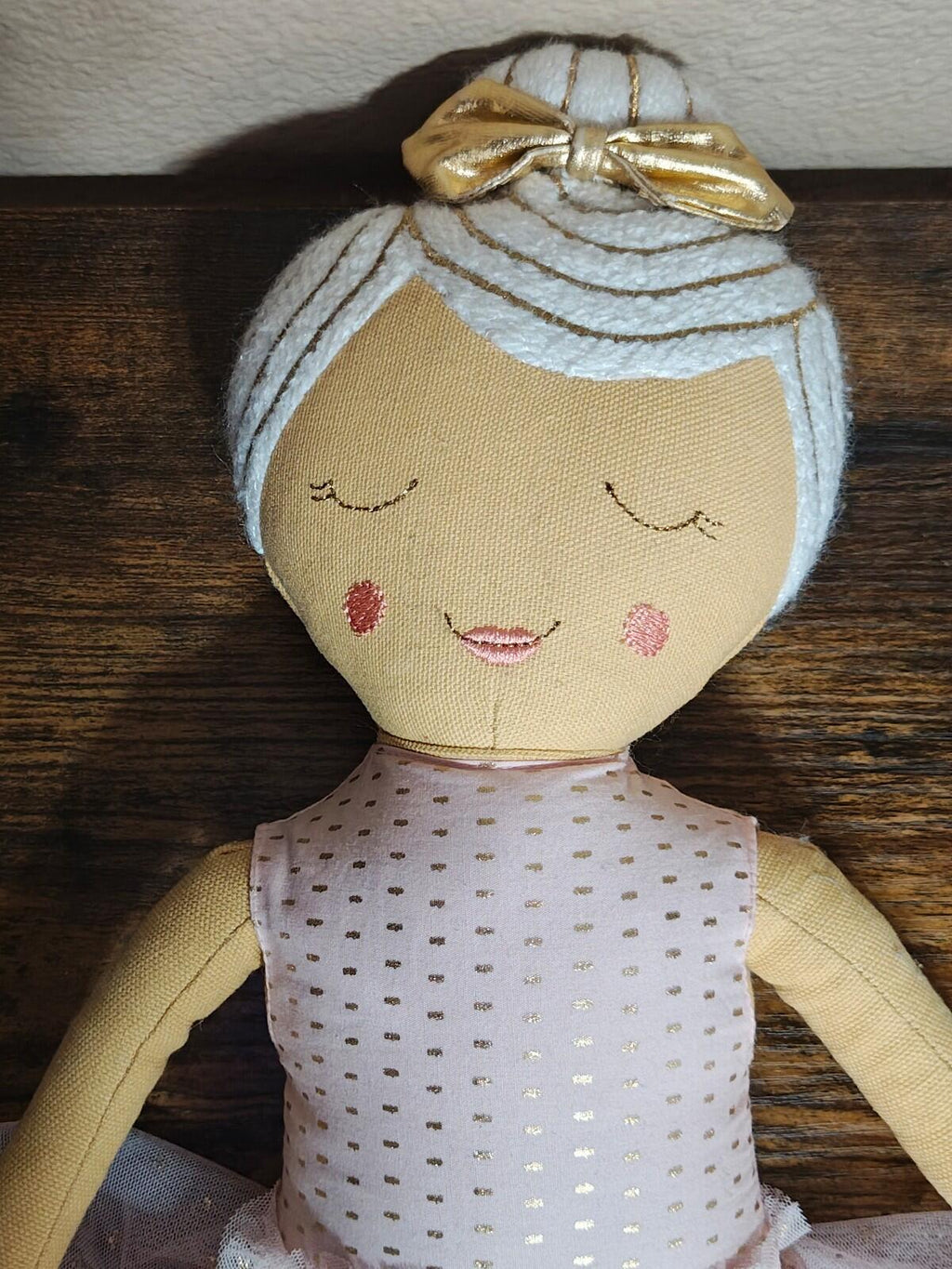 Pink ballerina plush doll pillow close-up: gold bow and dotted pink bodice