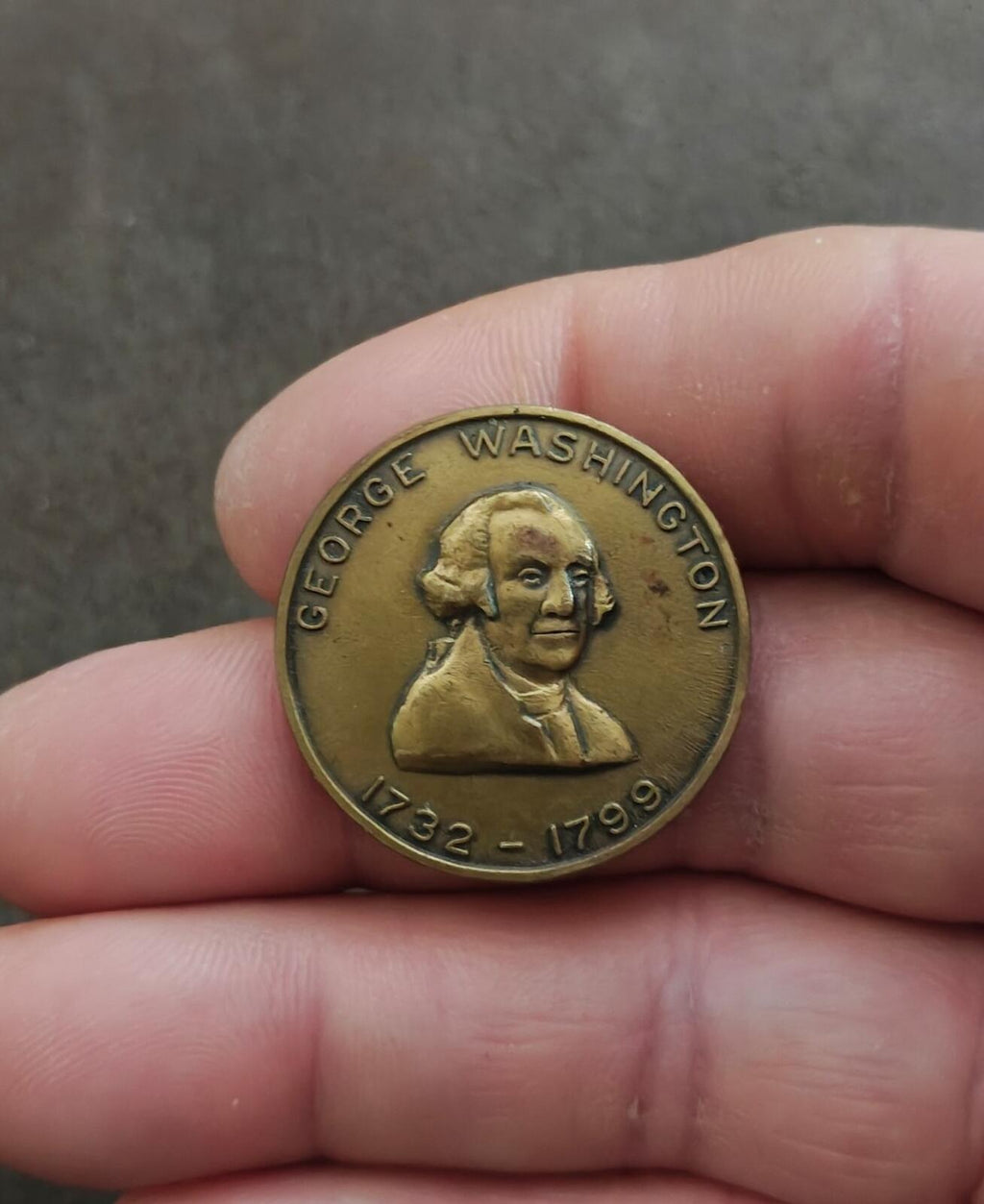 Gold George Washington commemorative bronze token shown in hand, portrait and 1732–1799