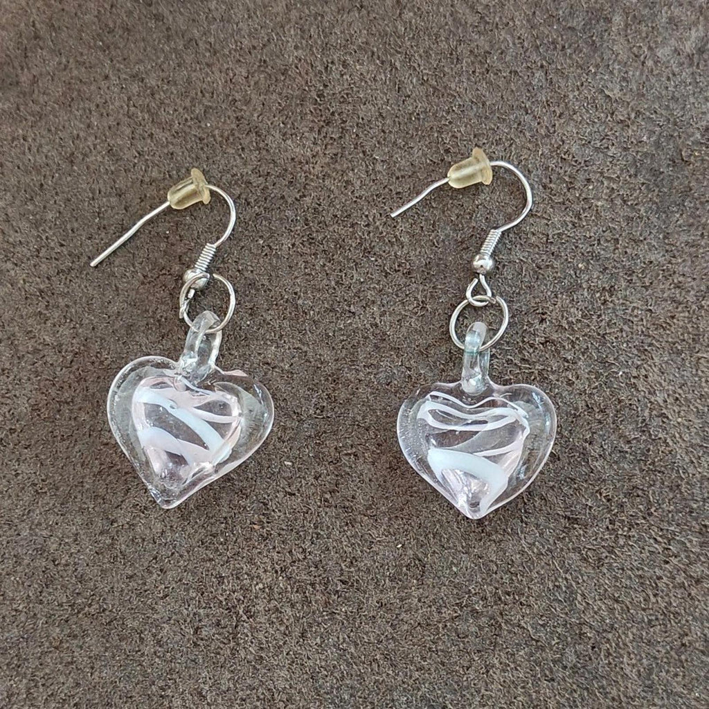 Heart-shaped glass earrings with swirl details and small dangling loop accents.