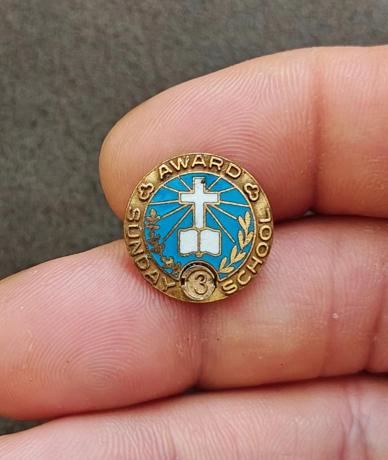 Close-up of vintage gold-tone Sunday School attendance award pin, blue enamel cross, laurel detail
