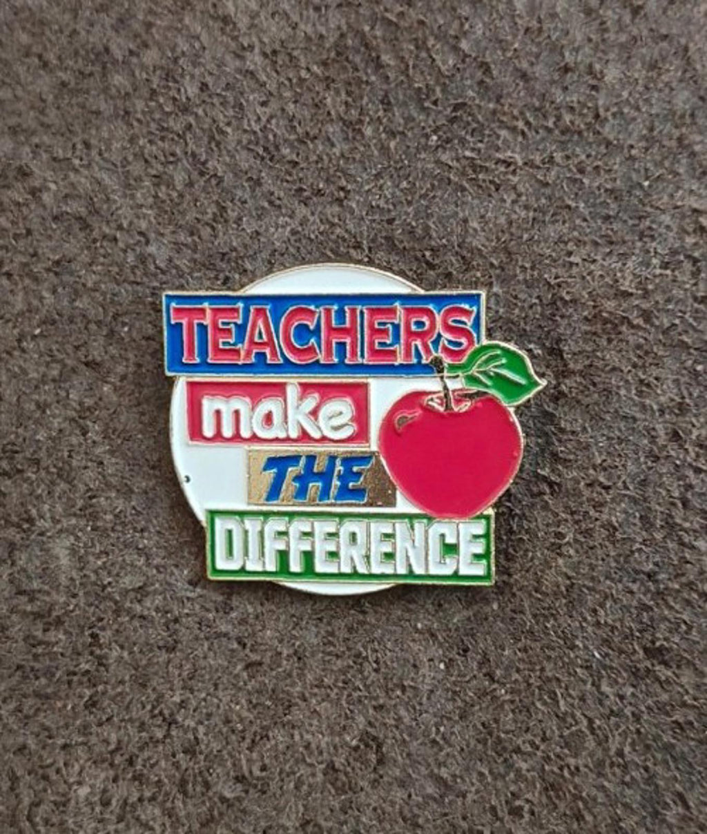 Enamel teacher pin front view with red apple and “Teachers make the difference”