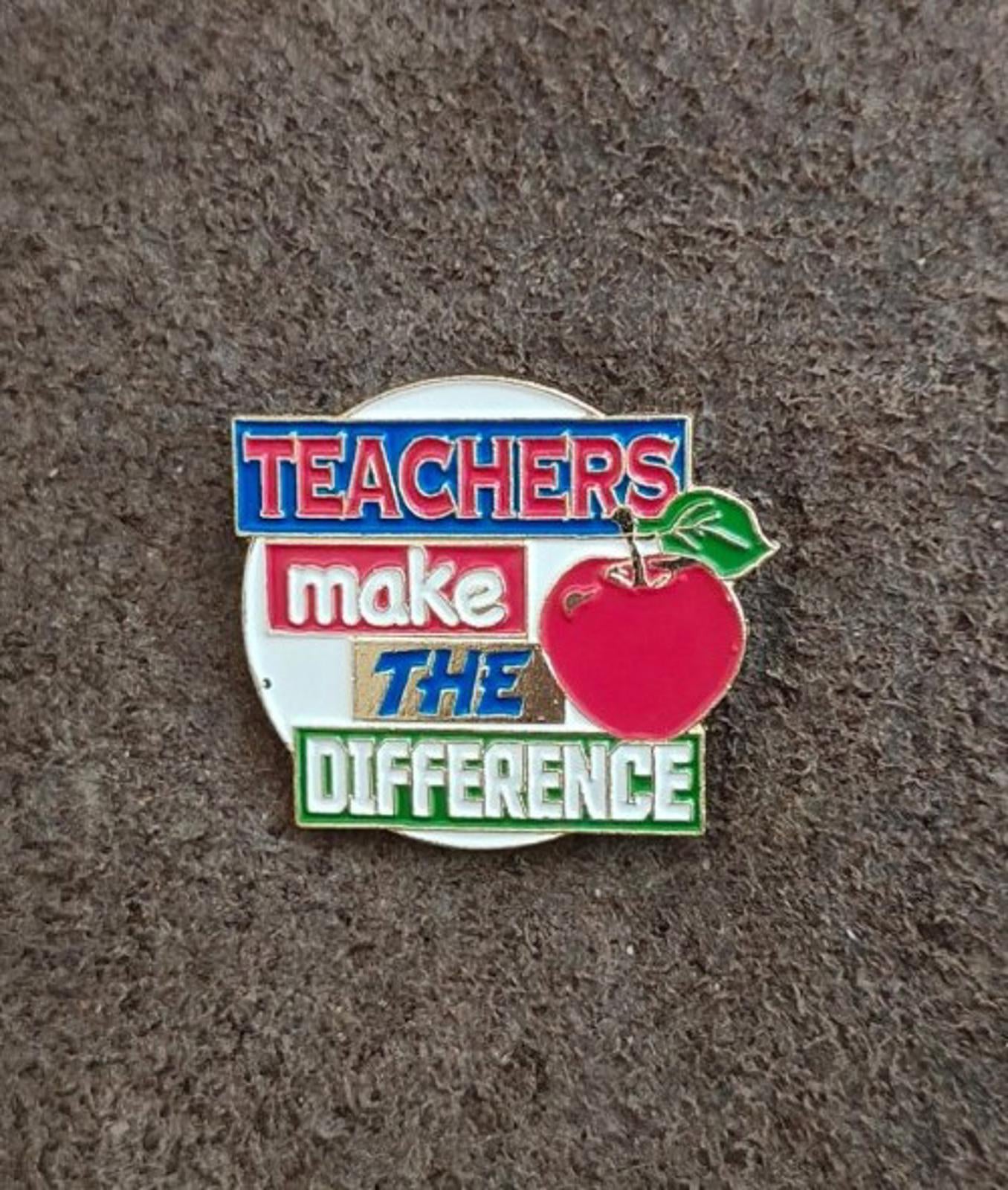 Enamel teacher pin front view with red apple and “Teachers make the difference”