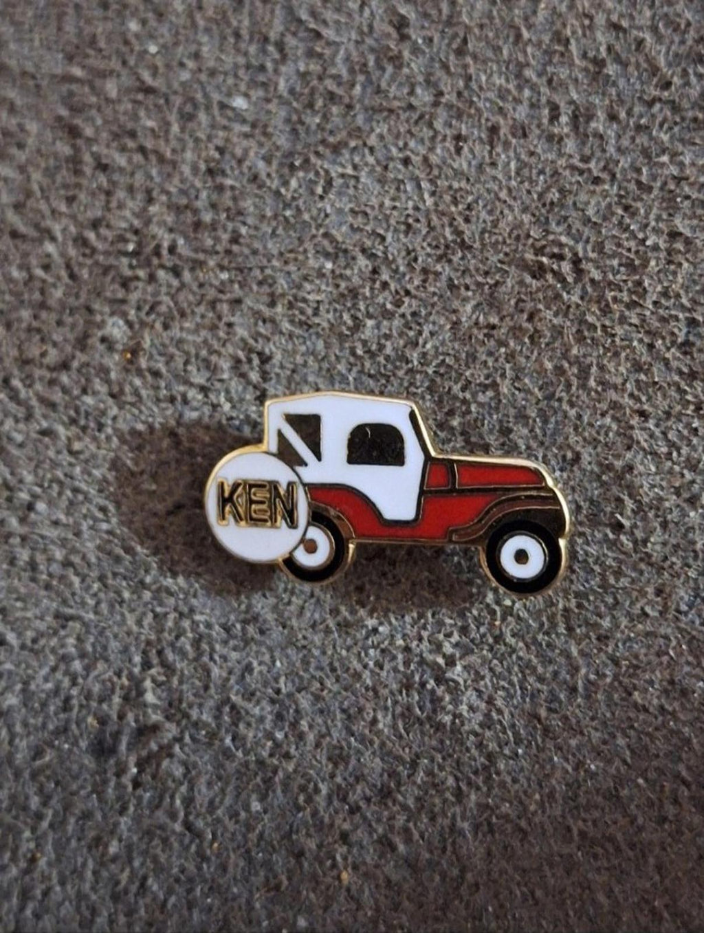 Jeep enamel pin with KEN on spare tire, white cab and red body with gold border