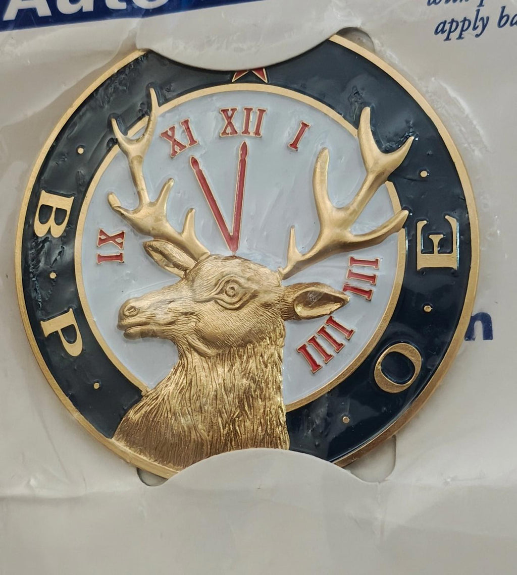 Close-up auto emblem: gold deer head with antlers and red roman numerals on blue