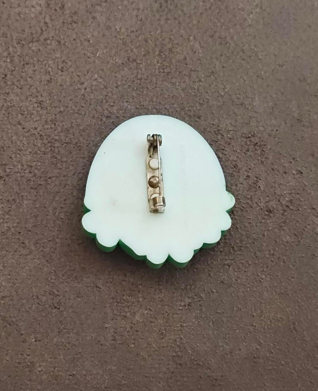 White clover-shaped brooch pin back with metal clasp and hinge