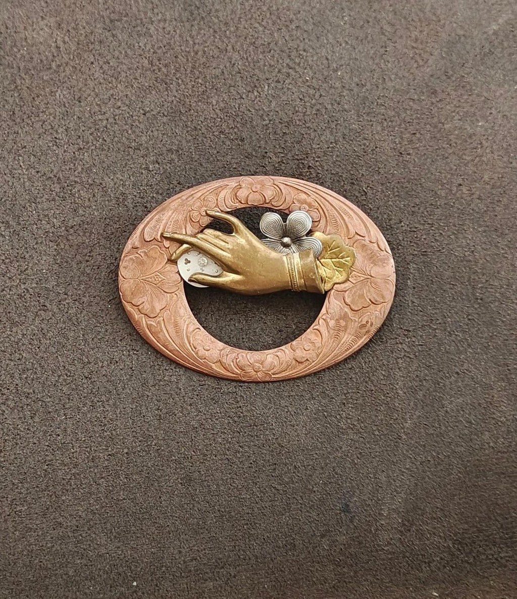 Small round steampunk brooch with engraved bronze rim, gold bird, and gray floral center
