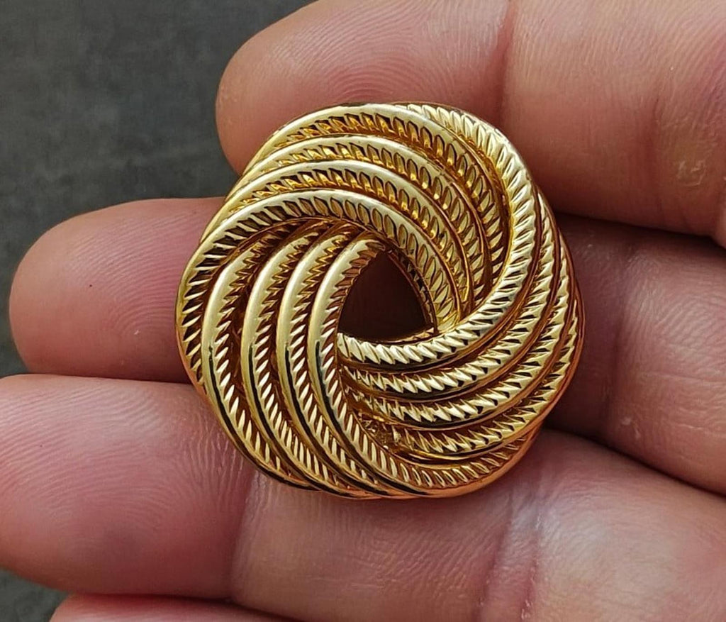 Gold tone swirl rope brooch pin with spiral ridges and dark cutout center