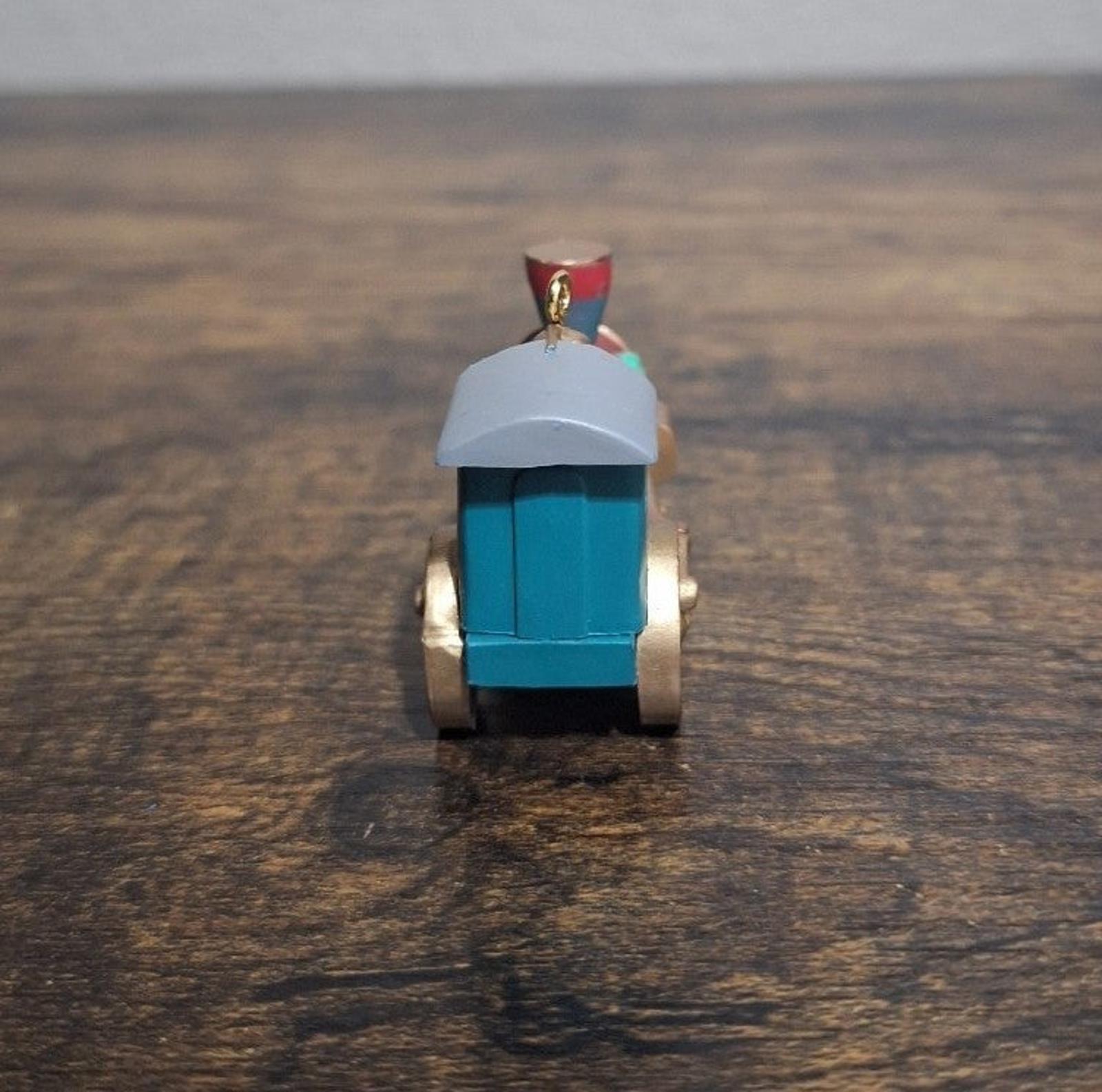 Blue train locomotive ornament, back view with small red roof emblem and hanging loop