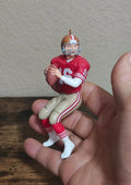 Red and white Joe Montana-style football player ornament, raised arms and standing pose