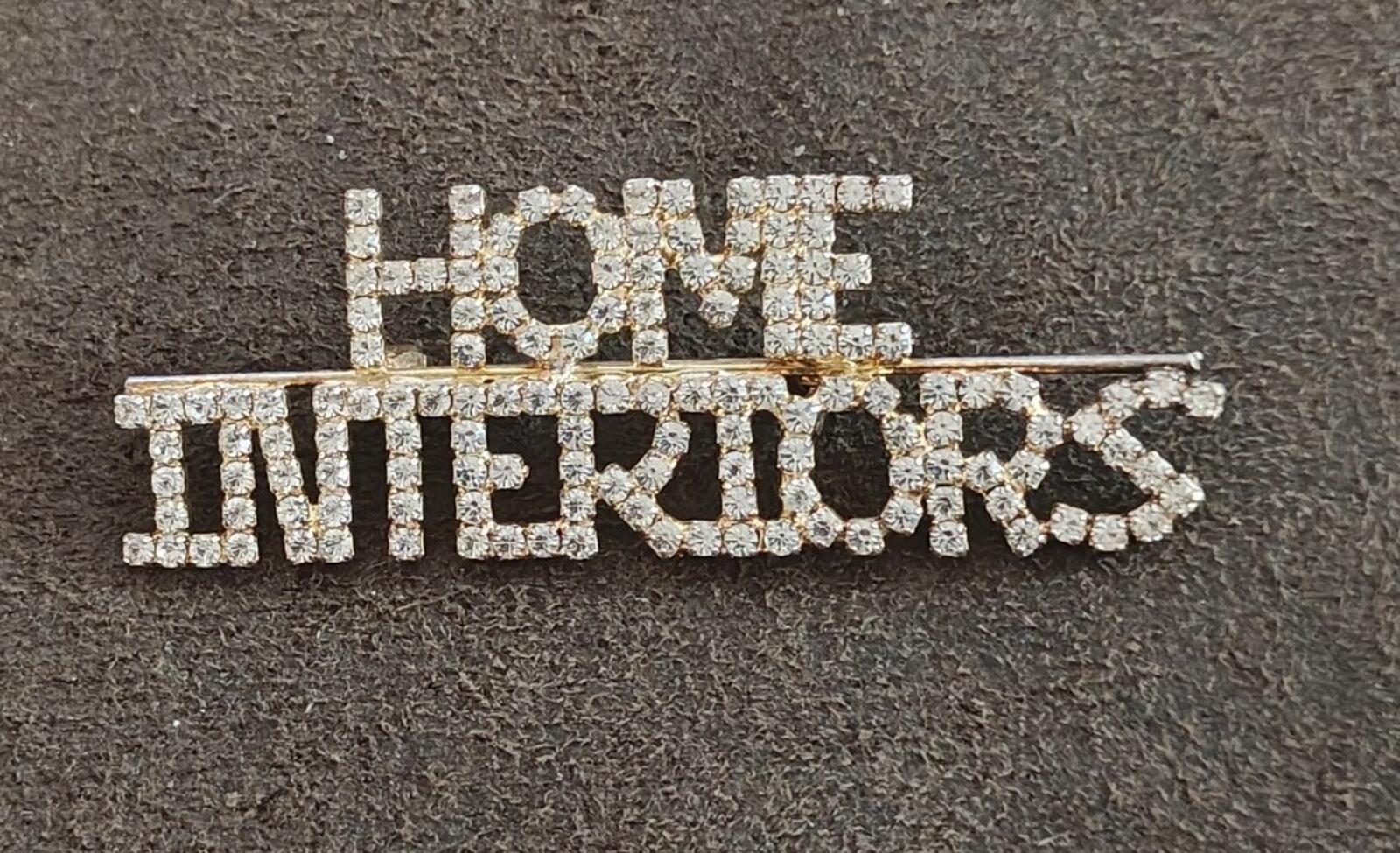 Rhinestone gold-tone brooch with "HOME" on top and "INTERIORS" below