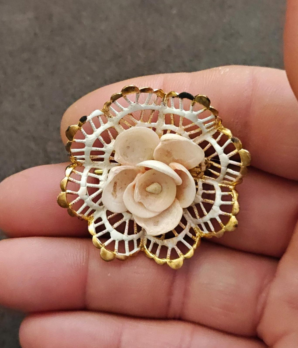 Gold-tone round filigree brooch with layered white rose flowers and lattice border
