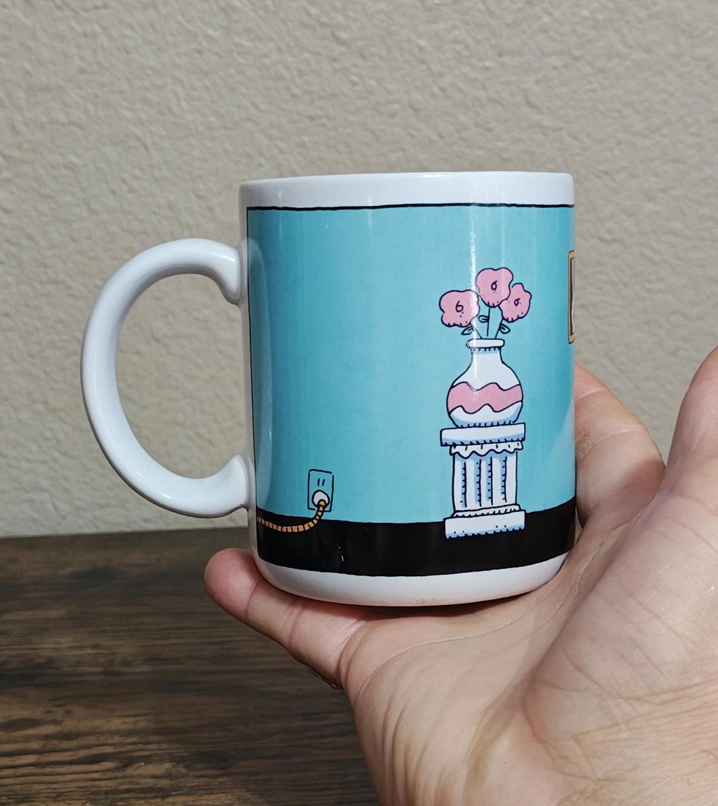 Blue ceramic mug with pink bunny-figure on pedestal and small rabbit icon