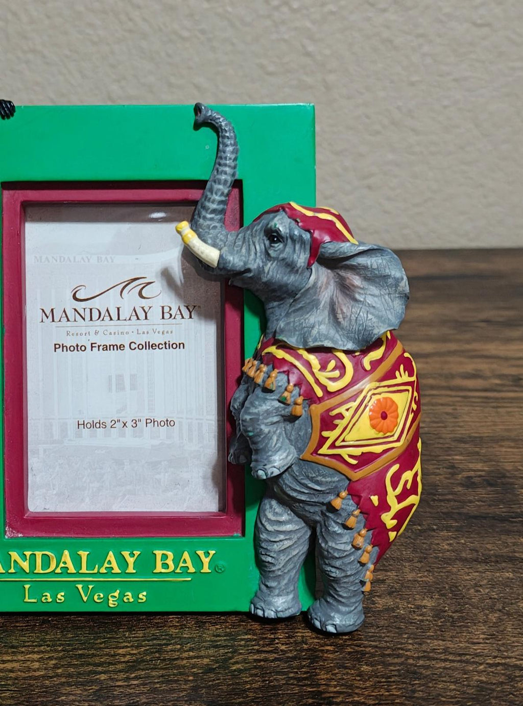 Green souvenir photo frame close-up of elephant figurine in front