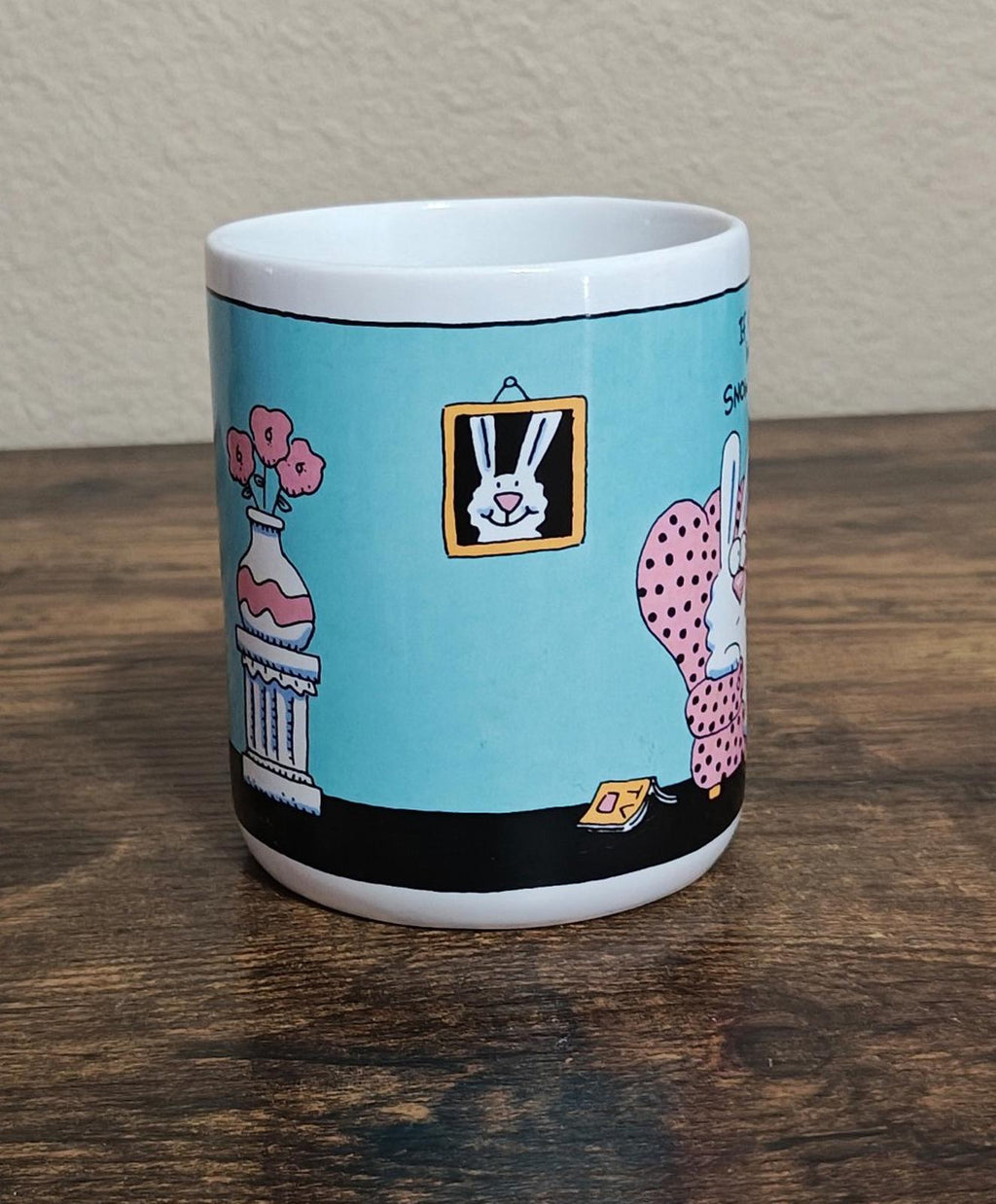 Blue ceramic mug side view with framed rabbit art and pink polka-dot bunny
