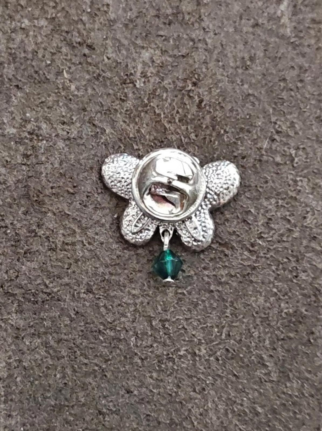 Silver-tone butterfly back pin with teal teardrop charm and round clasp