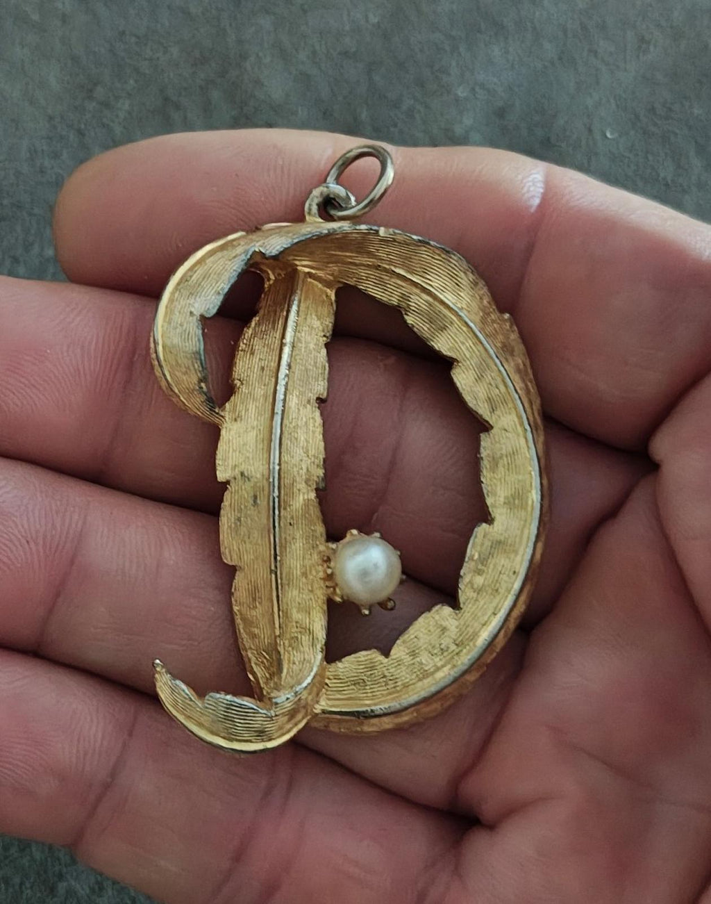 Gold-tone monogram pendant with raised letter D, pearl drop, and silver-tone bail