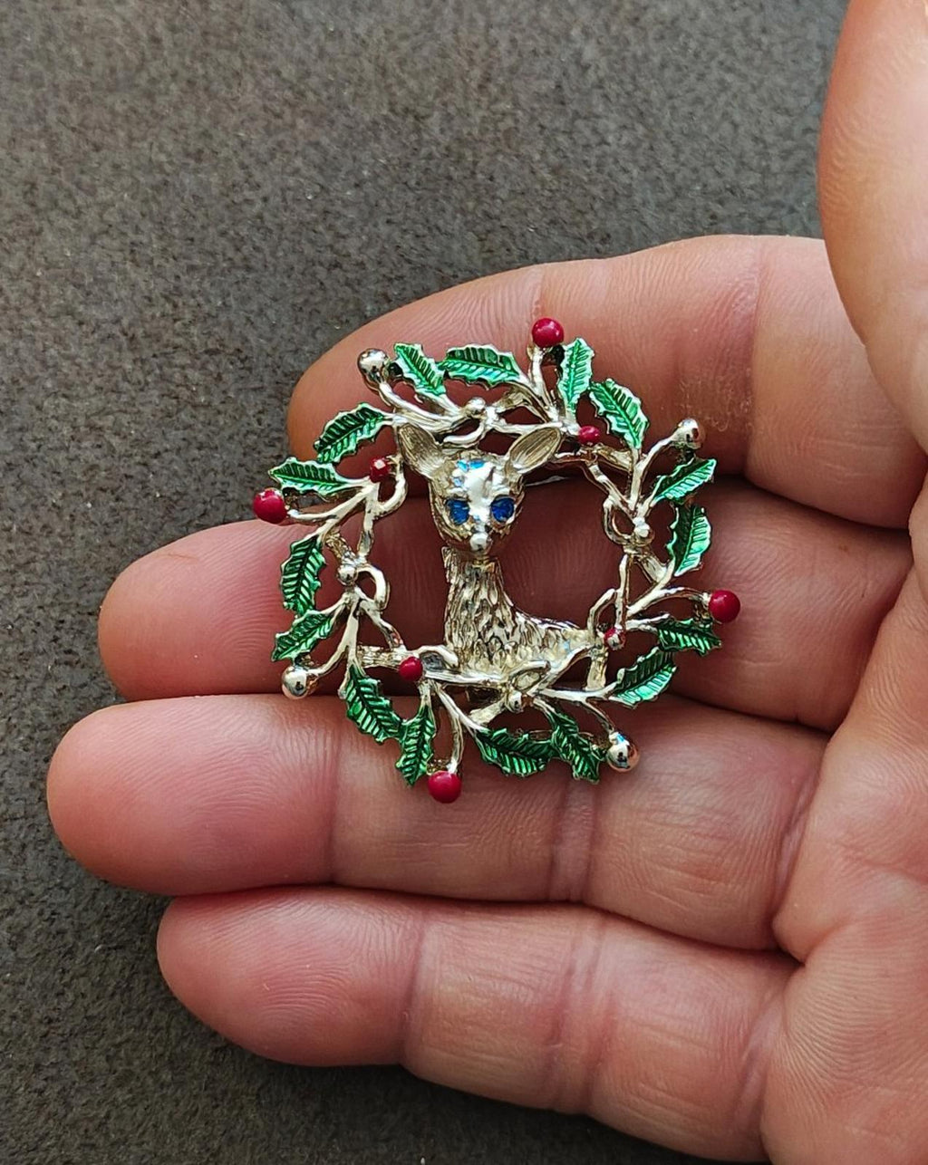 Reindeer in holly wreath brooch, gold tone with green enamel leaves and red berry accents