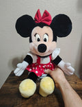 Minnie Mouse plush with red bow, red polka-dot dress, white collar, yellow feet