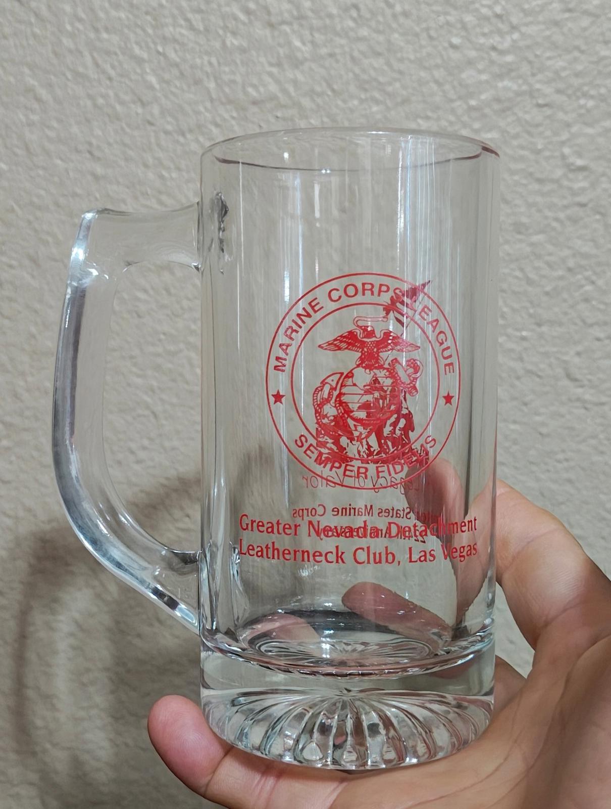Clear glass beer mug with handle, red circular Marine Corps logo and club text