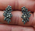 Silver tone floral leaf stud earrings with round rhinestones, clustered pinwheel design
