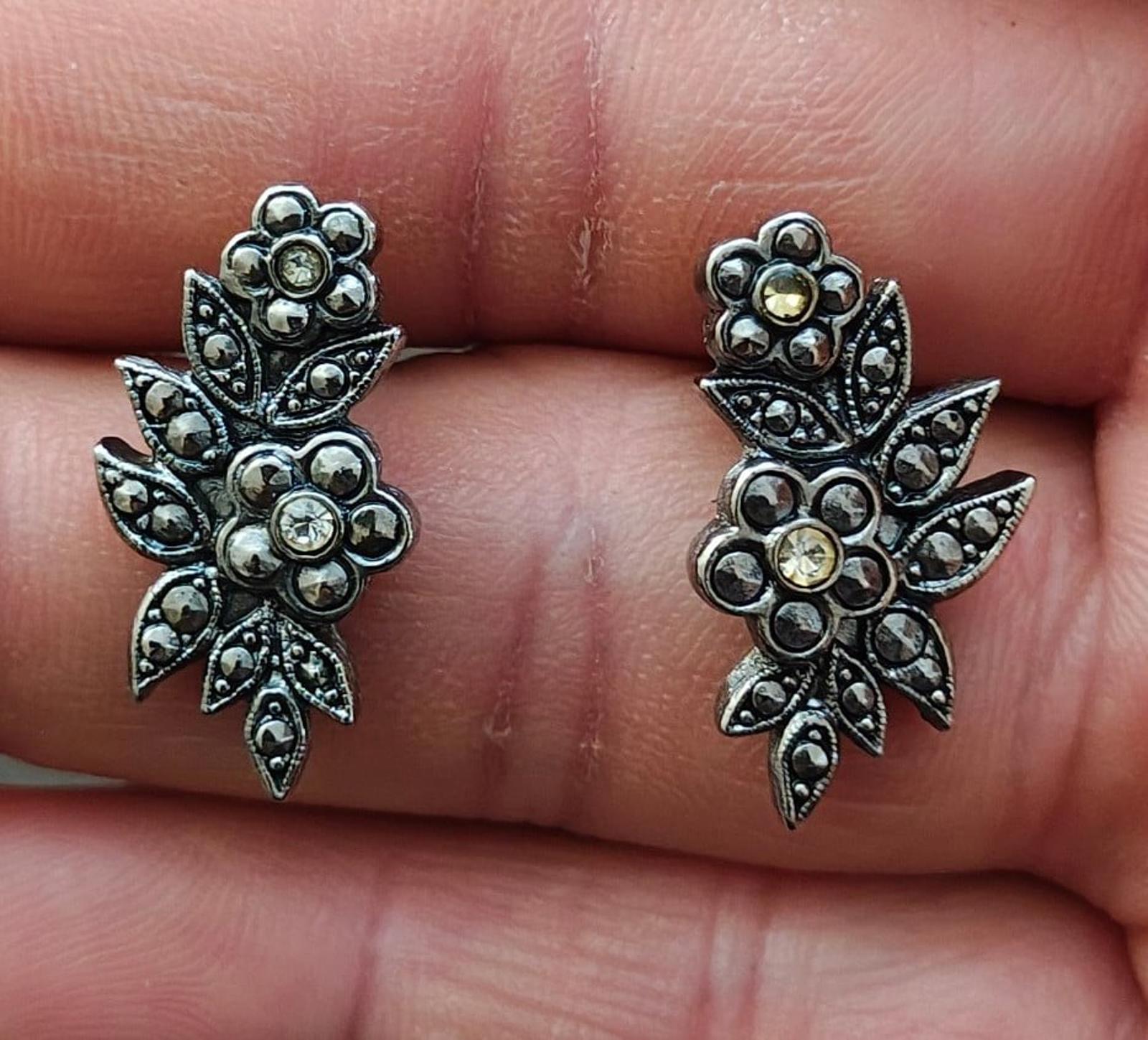 Silver tone floral leaf stud earrings with round rhinestones, clustered pinwheel design
