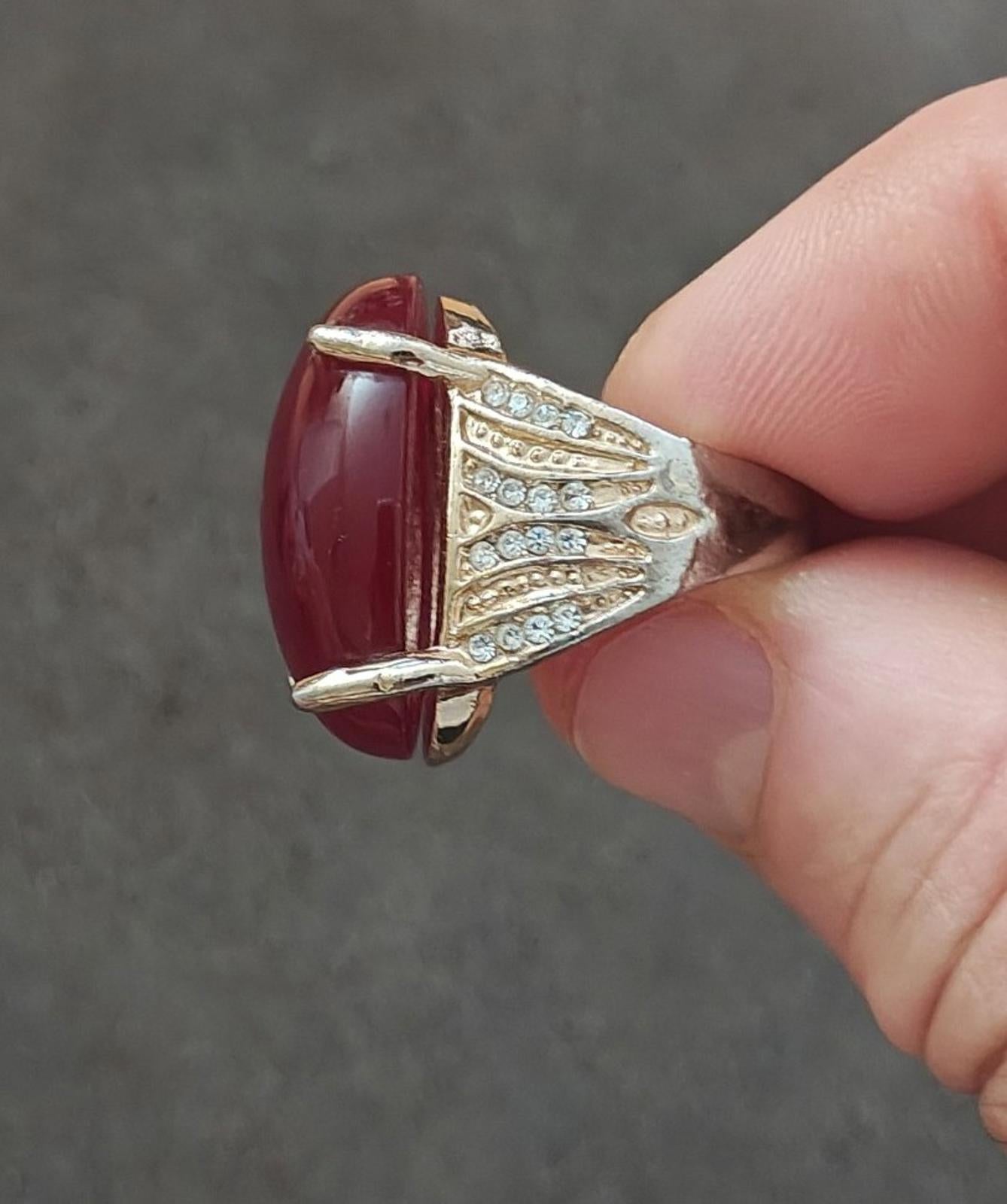 Red faux stone ring side view with gold-tone band and clear rhinestone detailing