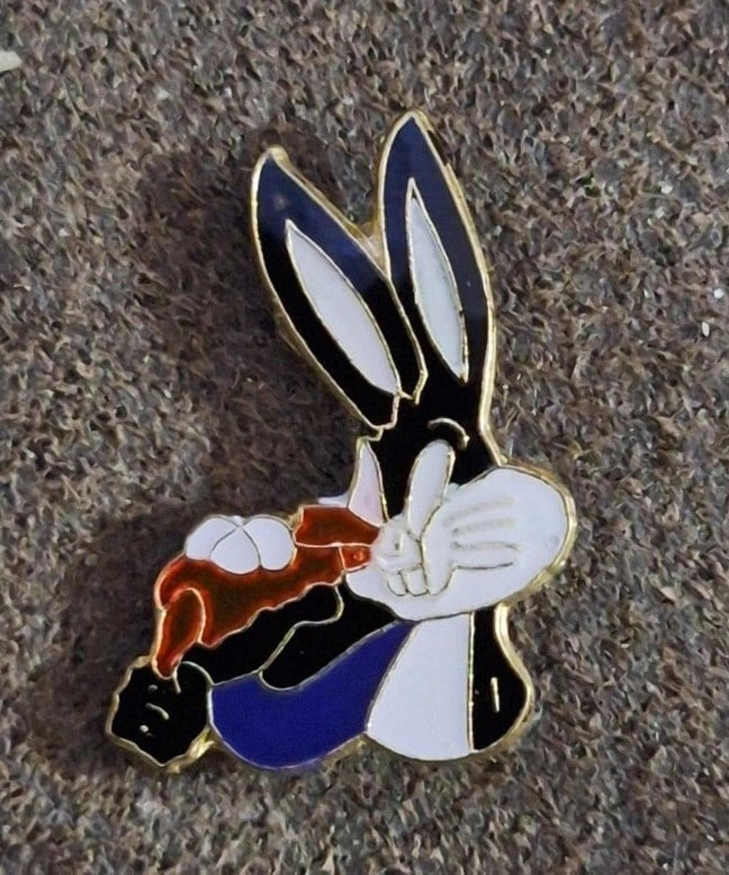 Enamel pin of Bugs Bunny holding carrot, close-up showing colorful enamel and gold border
