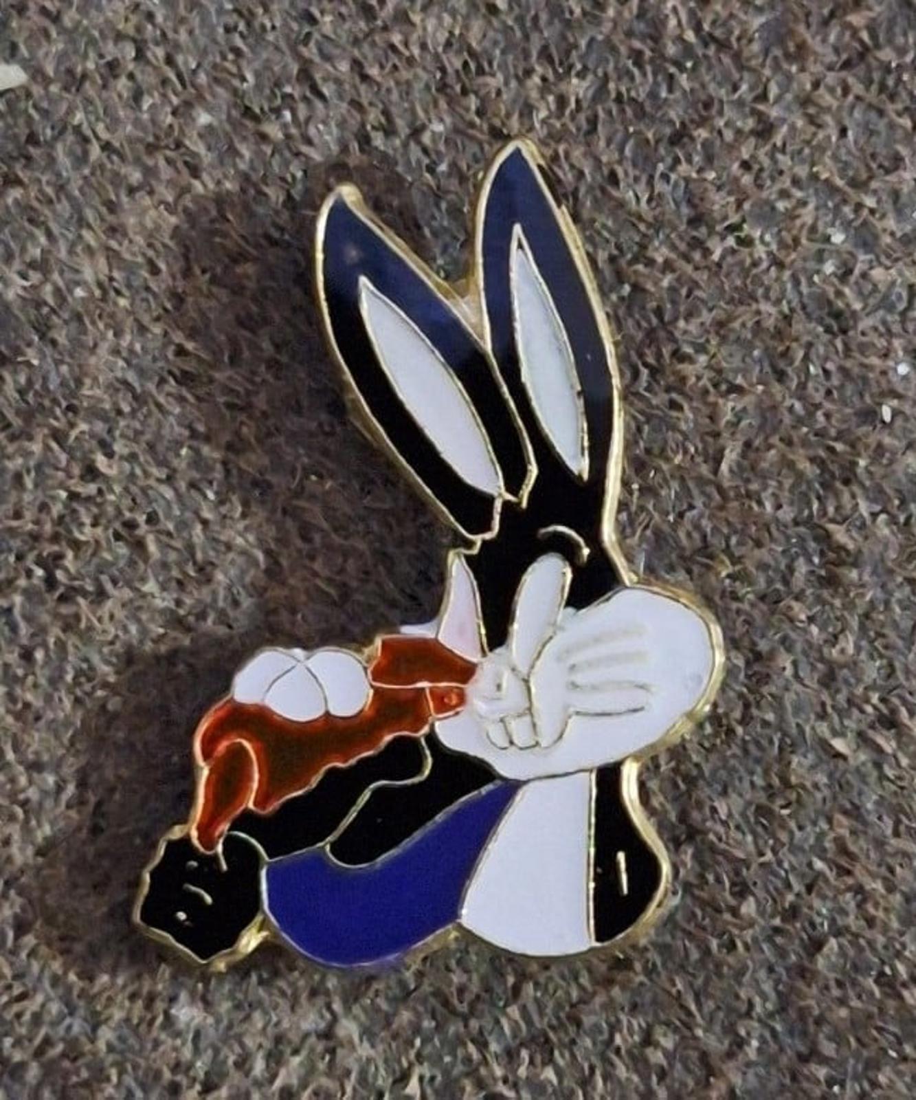 Enamel pin of Bugs Bunny holding carrot, close-up showing colorful enamel and gold border
