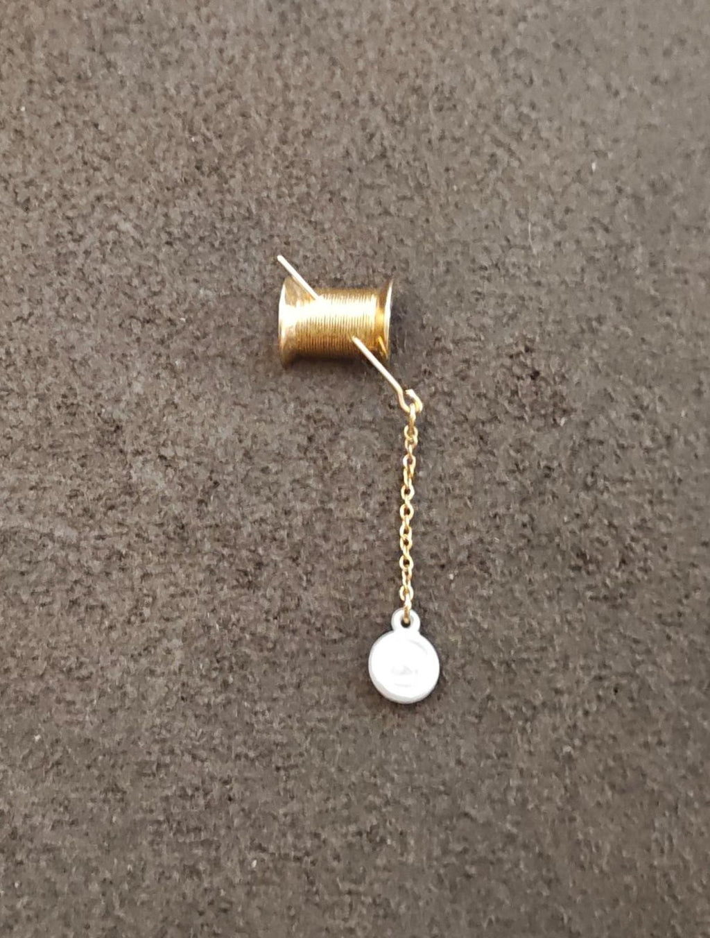 Gold-tone needle thread pin with dangling round button charm and chain