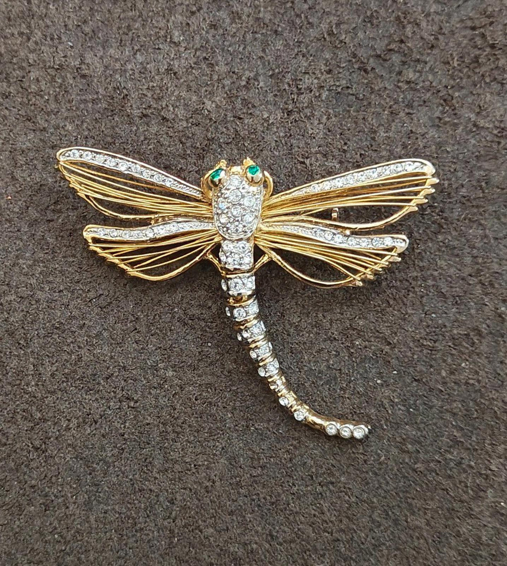 Gold-tone dragonfly rhinestone pin with green enamel eyes, centered full view