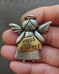 Silver tone angel pin brooch with wings and message panel reading HUGS R4FREE