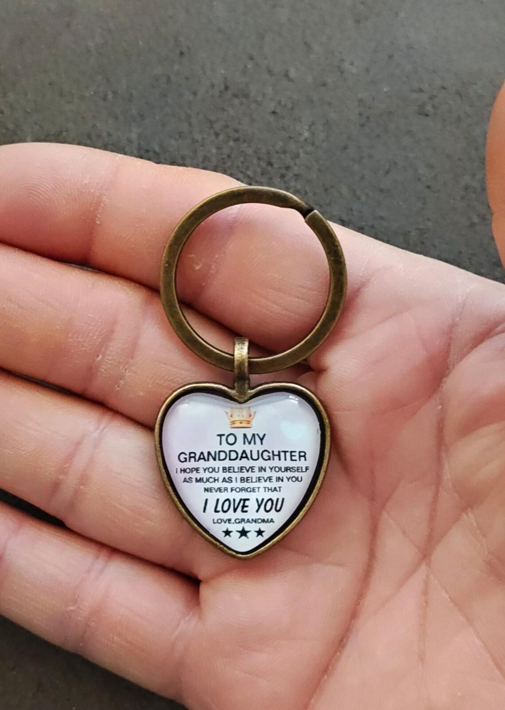 Brass-tone keychain with white heart pendant and engraved “To My Granddaughter” message