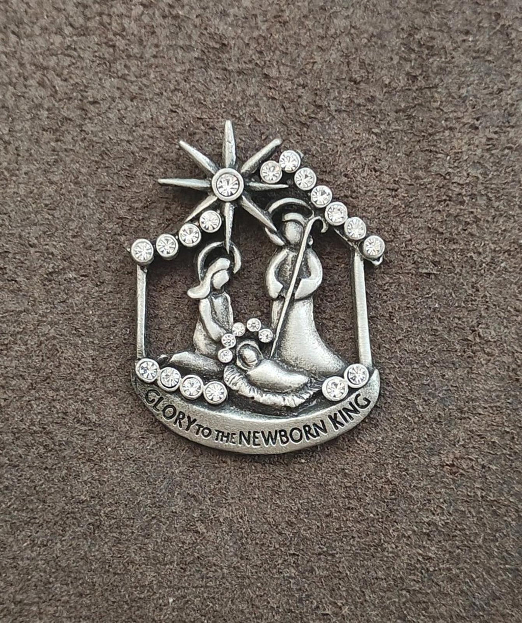 Silver nativity brooch featuring star and bowing figures, with rhinestone accents
