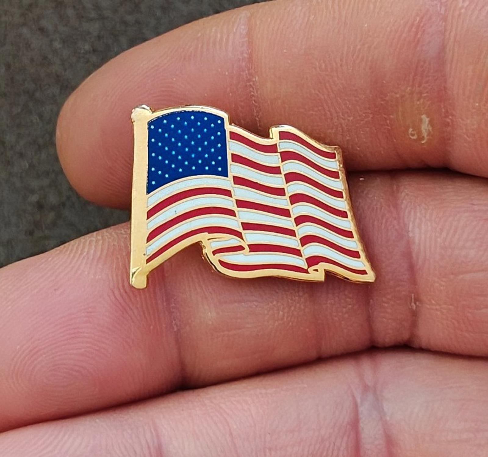 Gold tone wavy American flag enamel lapel pin with blue stars and red stripes