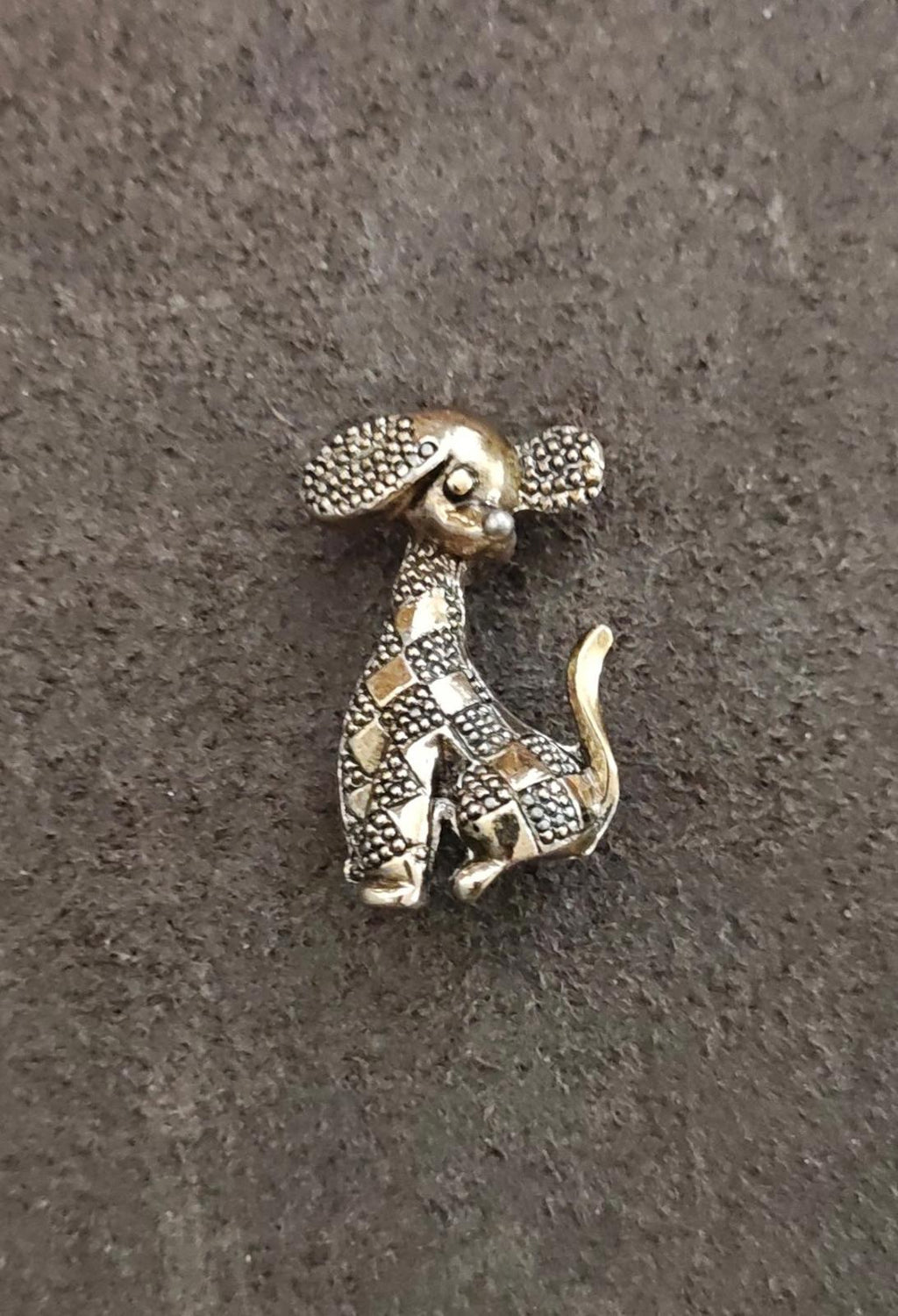 Gold-tone dog brooch front view with patterned texture and curled tail