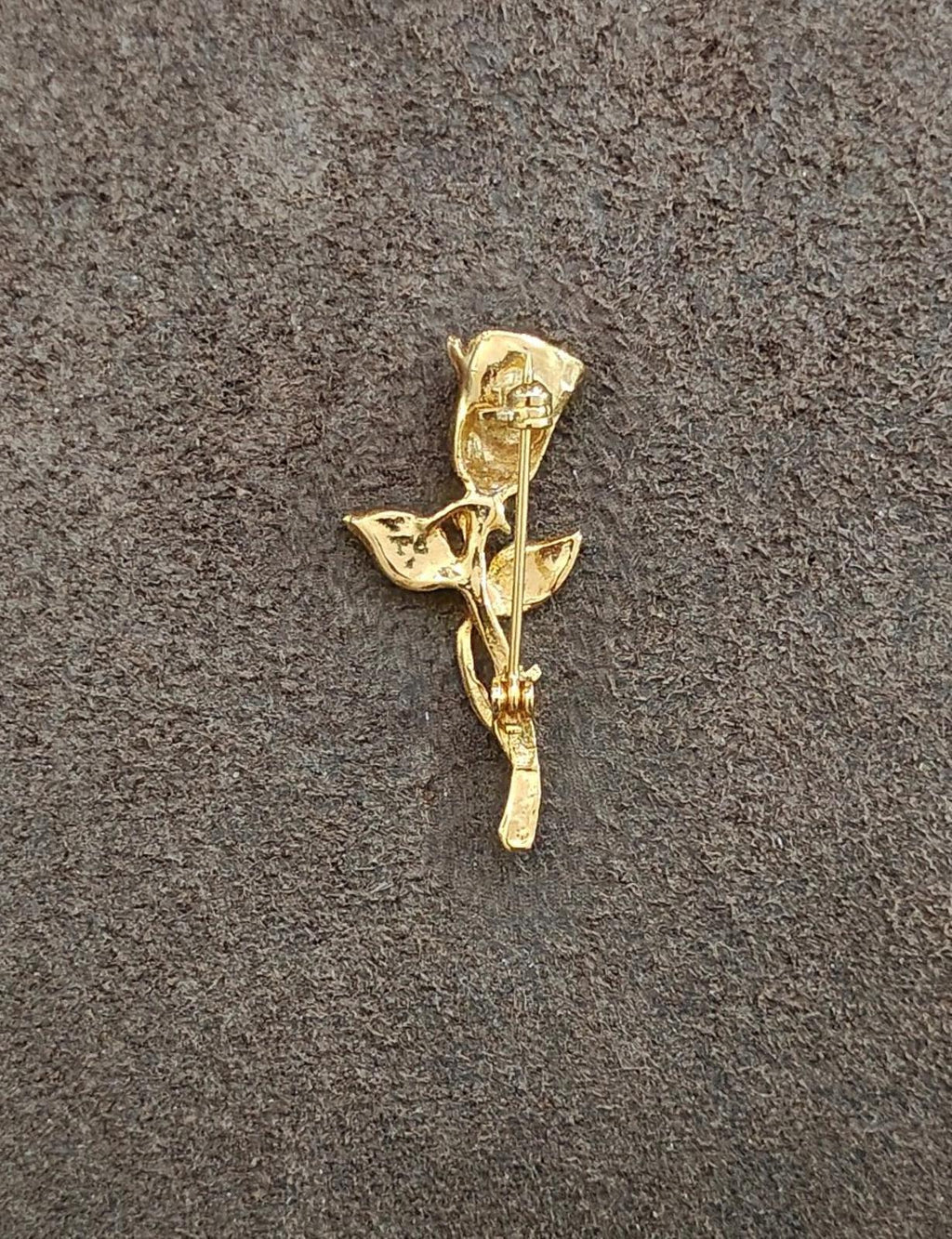 Gold-tone rose brooch with rhinestone, side view on fabric with clasp area visible